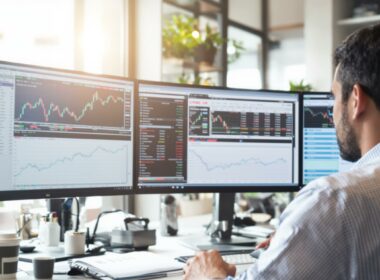 Man analyzing stock market data on multiple screens